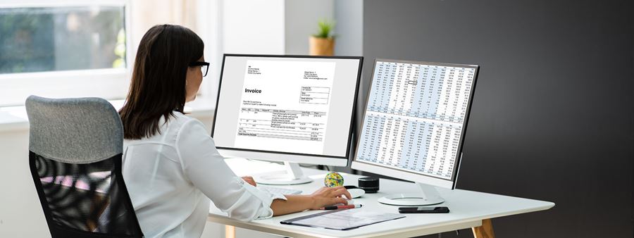 Woman working on a computer with two monitors